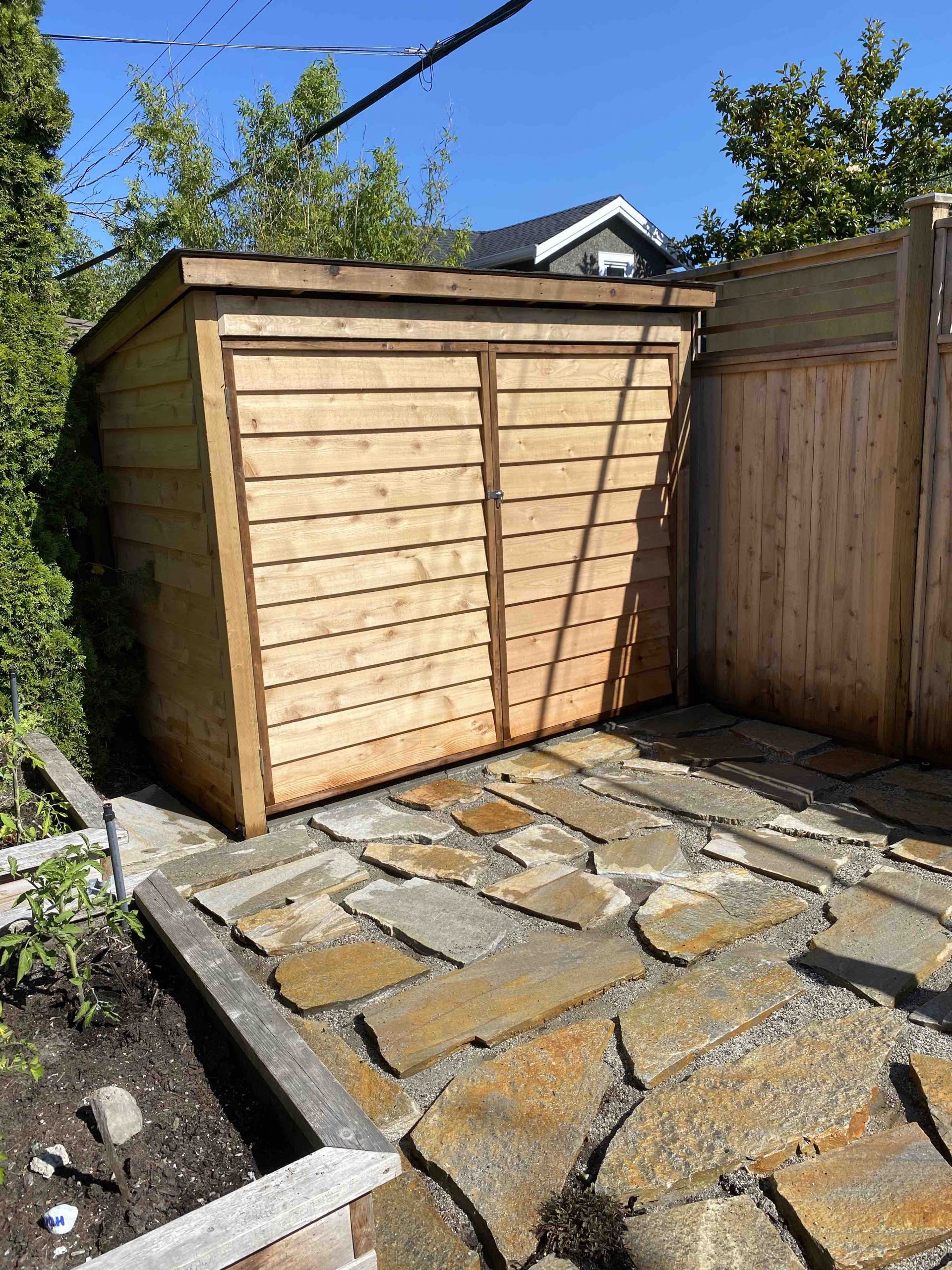 Custom bike shed in Vancouver backyard. Space efficient shed design with upright bike storage. Custom built with cedar siding